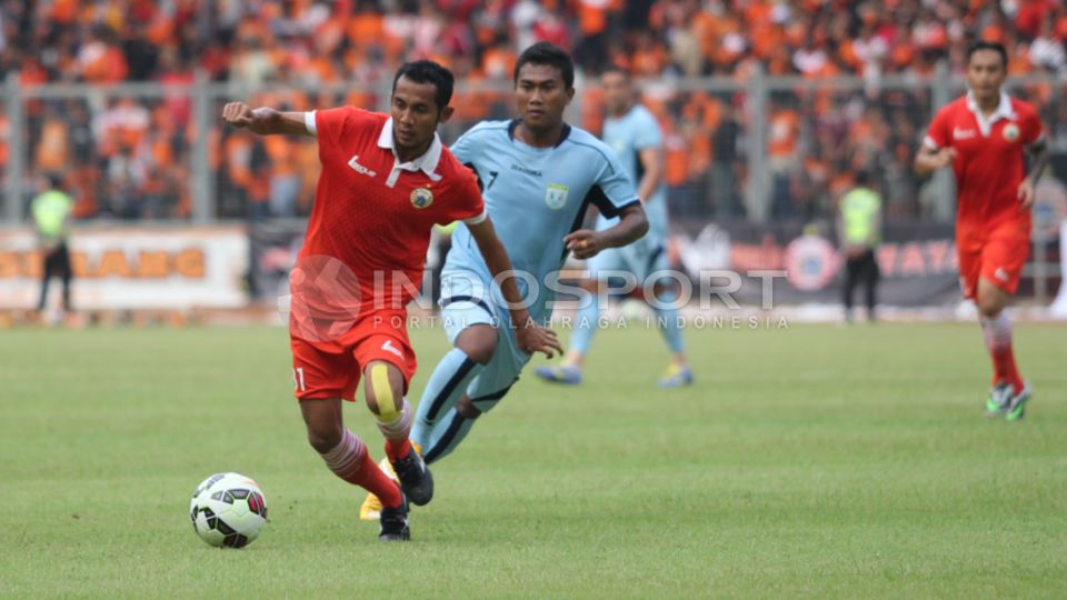 Pemain sayap Persija Jakarta M. Ilham (tengah) melewati Gelandang Persela Lamongan Arif Arianto pada laga uji coba di Stadion Utama Gelora Bung Karno (SUGBK) Senayan, Jakarta, Minggu (01/03/15). Copyright: &copy; Herry Ibrahim/INDOSPORT